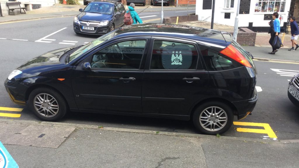 Double yellow lines painted around car in Llandudno