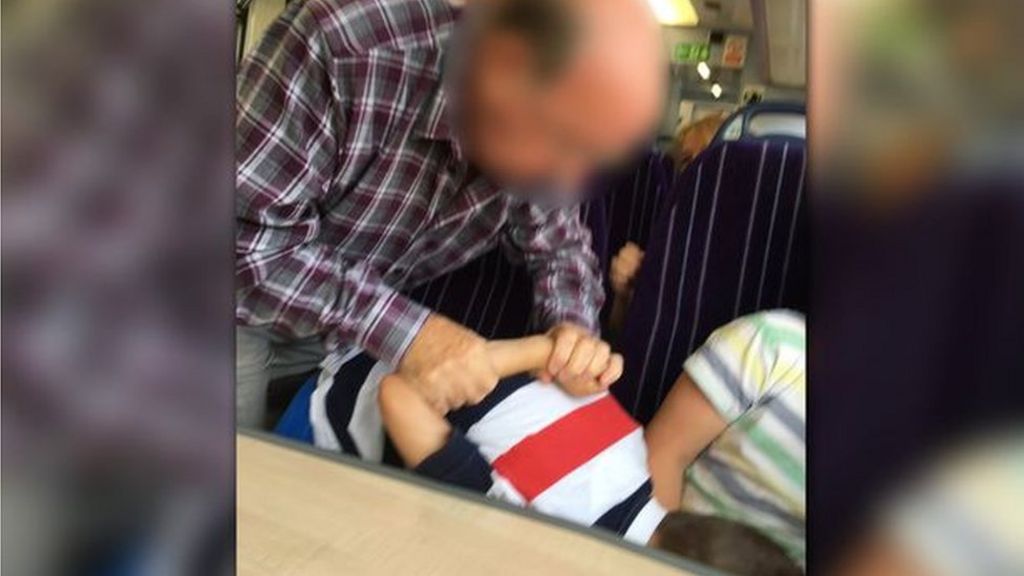 Child photographed in armlock on train to Manchester