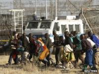 Protesting miners approach the police before they were fired upon near the Marikana mine on 16 August 2012