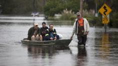 Neighbours carrying each other on boats in South Carolina on 6 October 2015