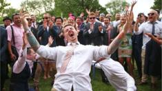 Man celebrates after completing a makeshift limbo at the Melbourne Cup