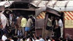 Rescue workers search for bodies inside the mangled compartment of one of the blast affected local trains at Mahim railway station in Mumbai, 11 July 2006.
