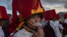 A Tibetan man smokes as he takes part in a local festival
