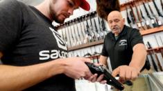 Bill Karnok, right, of Grandpa's Pawn Shop in Longmont, Colorado, shows Shane Angelovich a gun that he is interested in buying, 5 January