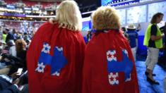 Supporters of Hillary Clinton with capes featuring her logo