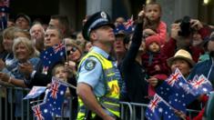 A policeman and members of the crowd look up as Royal Australian Air Force (RAAF) fighter jets fly overhead during the ANZAC (Australian and New Zealand Army Corp) Day march through central Sydney, Australia, April 25, 2016