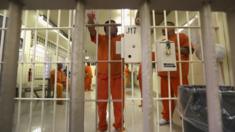 Immigration detainees stand behind bars at the Immigration and Customs Enforcement (ICE), detention facility on February 28, 2013 in Florence, Arizona.