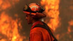 An inmate monitors a backfire during a burn operation to head off the Rocky Fire in August