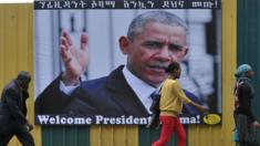 Ethiopians walk past a poster of US President Barack Obama in Addis Ababa on 27 July 2015