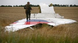 Pro-Russian separatis stands on MH17 wreckage (file pic Jul 2014)