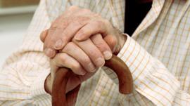 elderly man hands on walking stick