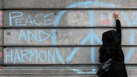 A woman writes a messages of support on the walls of the Bourse De Brussels building in the Place de la Bourse following the previous day's terrorists attacks on 23 March 2016 in Brussels, Belgium