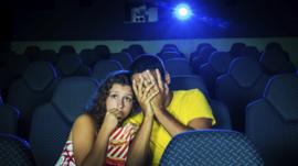 Couple looking shocked in cinema
