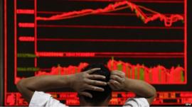 An investor monitors stock data on an electronic board at a securities brokerage house in Beijing, China