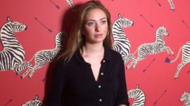 Whitney Wolfe standing in front of patterned wallpaper