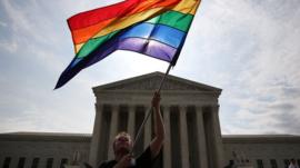 Man waves rainbow flag in front of US Supreme Court building