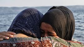 Women hugging and crying after making the crossing from Turkey to the island of Lesbos