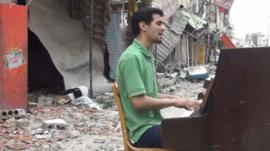 Ayham playing the piano in Yarmouk camp