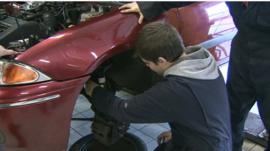 Trainee mechanic works on a car