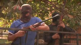 Men in masks holding guns