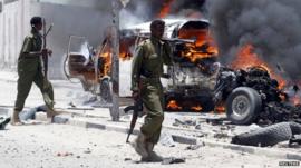 Police officers near burning vehicle