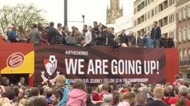 Bournemouth players and fans celebrate during an open-top bus parade in the town