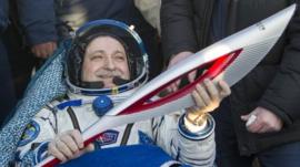 Television images showed the Sochi Olympic torch and the crew of the Soyuz rocket landing back on Earth