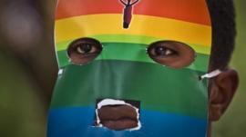 A Kenyan gay man wears a mask to preserve his anonymity as he protests against anti-gay moves in Uganda outside the Uganda High Commission in Nairobi, Kenya on 10 February