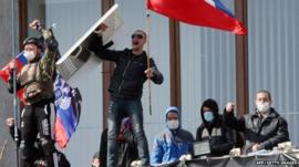 Pro-Russian activists who seized the main administration building in the eastern Ukrainian city of Donetsk hold Russian flag and flag of so-called