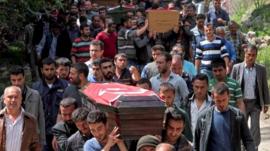 People carrying a coffin in Soma