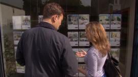 People looking in an estate agent window