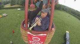 A trumpeter in a hot air balloon basket
