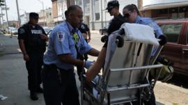EMTs help someone on a stretcher