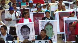People march holding posters of the missing students