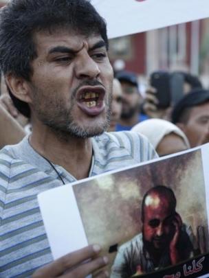 Un hombre sostiene una foto de Mouchine Fikri