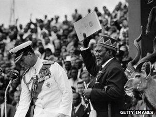 Jomo Kenyatta (right) holds official document of independence, December 1963