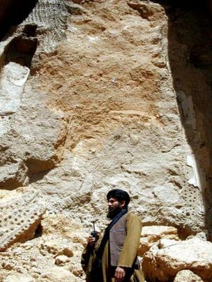 A Taliban member at the site of the destruction