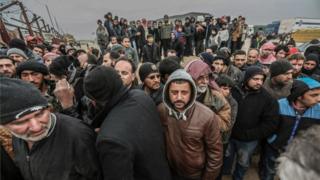 Syrians gather at the Bab al-Salam border gate with Turkey, in Syria, Saturday, Feb. 6