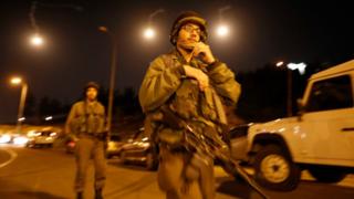Israeli soldiers block the entrance to the Israeli Jewish settlement of Otniel, in the West Bank, on Sunday after a Palestinian stabbed a woman to death in her home