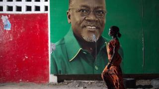 A woman walks past an election billboard after ruling party Chama Cha Mapinduzi (CCM) candidate John Magufuli (pictured on the billboard) was named president-elect by the National Electoral Commission in Dar es Salaam, on October 29, 2015.