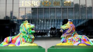 A photo of the two rainbow coloured lions outside the HSBC main building in Hong Kong