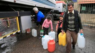 People carry plastic containers with water in Damascus, Syria (16 January 2017)