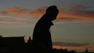 Silhouette of man walking with headphones