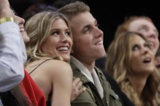Eugenie Bouchard, left, poses for photographs with her blind date, John Goehrke, right, during the second half of an NBA basketball game