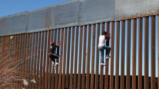 Boys climb border fence at Ciudad Juarez