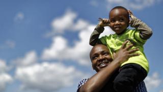 A child covers his ears from the noise as vintage biplanes perform a flyover after arriving in Nairobi National Park in Kenya, Sunday 27 November 2016