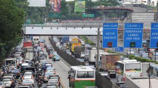A picture shows an express lane dedicated for special commuter buses running alongside a congested highway in Jakarta