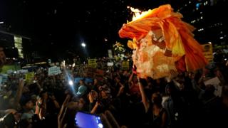Manifestantes en Los Ángeles, California, queman una piñata con la cara de Donald Trump _92376561_trumppinatareu.jpg