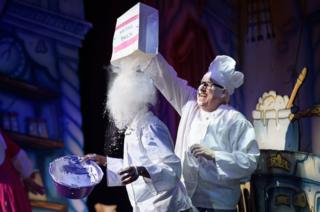 Darren Hart (Ikoboo, L) is covered with "flour" by Tony Whittle (King Eric) during a performance of the traditional pantomime "Sleeping Beauty" at the Hackney Empire