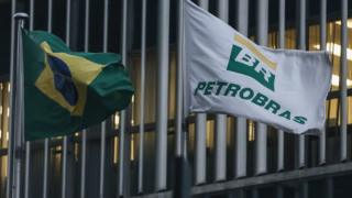 A Brazilian flag and a Petrobras flag fly in front of Petrobras headquarters in Rio de Janeiro on 13 April, 2016